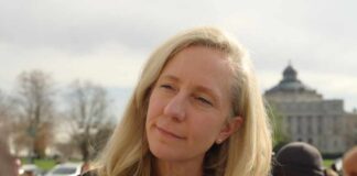 Governor’s Approval IMPLODES Just Months After Victory A woman with blonde hair speaking outdoors with a city building in the background