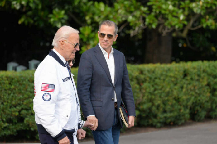 Two men walking outdoors, one in a jacket with an American flag, the other in a blazer