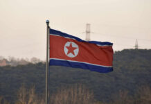 North Korean flag waving against a mountainous backdrop