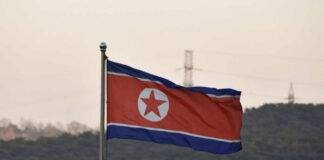 North Korean flag waving against a mountainous backdrop