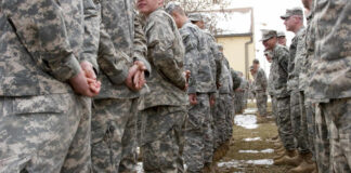 A line of soldiers in military uniforms standing outdoors in formation