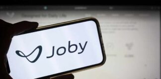 A hand holding a smartphone displaying the Joby logo