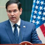 Rubio Warns – NATO’s Future in Jeopardy Marco Rubio speaking at a podium with an American flag in the background