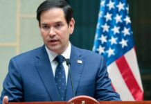 Rubio Warns – NATO’s Future in Jeopardy Marco Rubio speaking at a podium with an American flag in the background