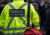 Sword-Wielding Attacker Stuns First Responders Medical first responder wearing a bright yellow jacket and carrying a red bag