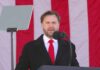 Man speaking at a podium with an American flag backdrop