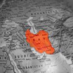 Map highlighting Iran in orange on a grayscale background