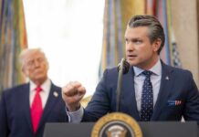 A government official delivering a speech at a podium with a presidential seal