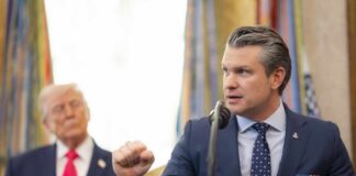 A government official delivering a speech at a podium with a presidential seal