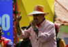 Maduro’s Fixer Shipped to U.S.—Corruption Trial Looms A man in a straw hat passionately speaking into a microphone at a lively outdoor event