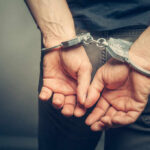 Hands cuffed behind the back, symbolizing arrest