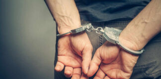 Hands cuffed behind the back, symbolizing arrest