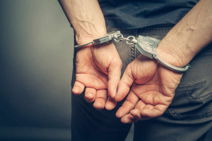 Hands cuffed behind the back, symbolizing arrest