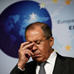 A political figure with a serious expression during a press conference