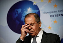 A political figure with a serious expression during a press conference