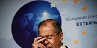 A political figure with a serious expression during a press conference