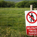 A warning sign indicating a military firing range with a no entry symbol