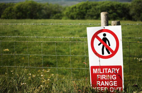 A warning sign indicating a military firing range with a no entry symbol