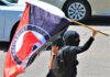 Individual holding an antifascist flag during a protest