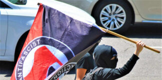 Individual holding an antifascist flag during a protest