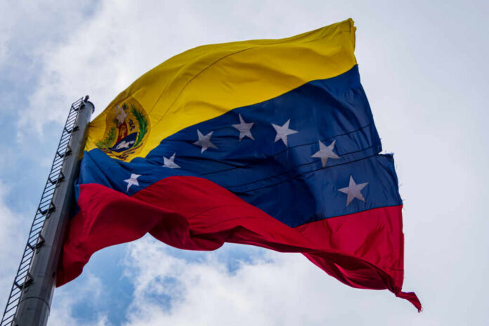 Venezuelan flag waving against a blue sky