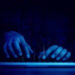 Indonesia’s Bold Move: Huge Cybercrime Raid Hands typing on a keyboard with a digital binary background