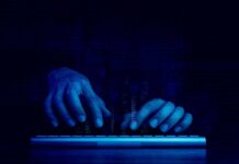 Hands typing on a keyboard with a digital binary background