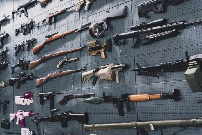 Person holding an AK-47 rifle with a scope