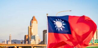 Taiwan Arms Deal FROZEN – China’s Influence Wins? Taiwan flag waving in front of a city skyline during sunset
