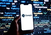 A hand holding a smartphone displaying the DeepL logo against a programming code background