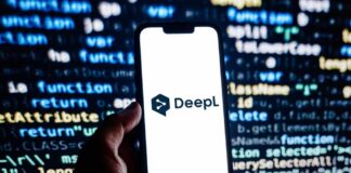 A hand holding a smartphone displaying the DeepL logo against a programming code background