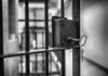 Close-up of a jail cell lock with a key hanging