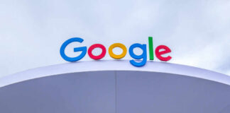 Colorful Google logo displayed on a modern structure against a cloudy sky