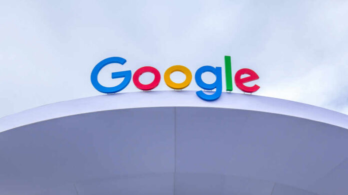 Colorful Google logo displayed on a modern structure against a cloudy sky