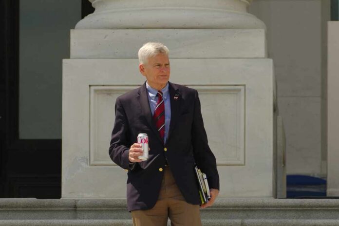 man in blazer holding a soda can on building steps