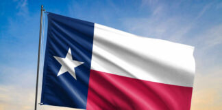 Texas state flag waving against a sunset sky
