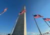 Washington Monument surrounded by American flags under a clear blue sky