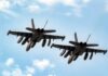 Two military fighter jets flying in formation against a blue sky