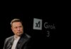 Elon Musk speaking during a technology event with a dark background