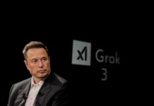 Elon Musk speaking during a technology event with a dark background