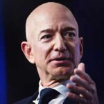 A bald man in a suit speaking at a conference