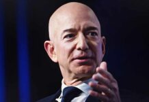 A bald man in a suit speaking at a conference