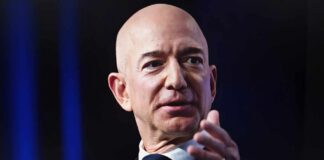 A bald man in a suit speaking at a conference