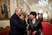 Two individuals shaking hands in a formal setting