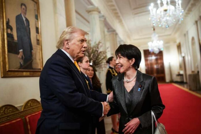 Two individuals shaking hands in a formal setting