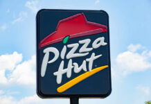 restaurant sign with red roof logo against blue sky