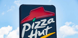 restaurant sign with red roof logo against blue sky