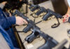 A customer examining handguns at a firearms shop display