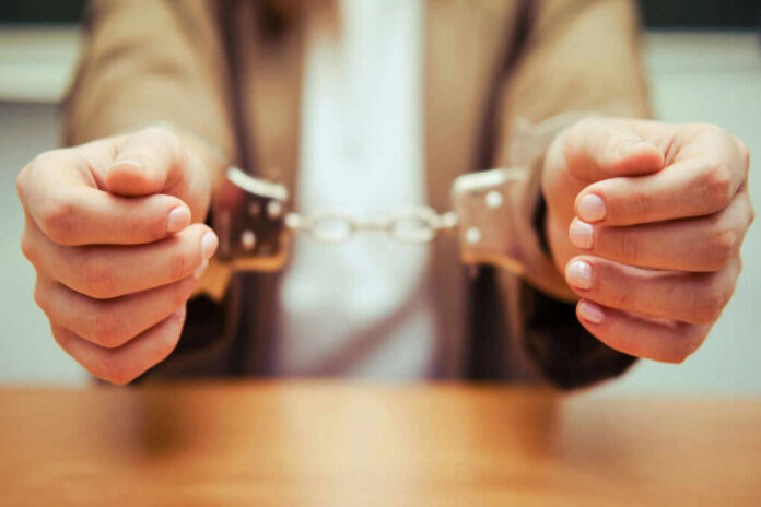 shutterstock1821690536jpg Close-up of hands holding handcuffs in a serious context