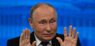 A political leader gesturing with hands during a press conference